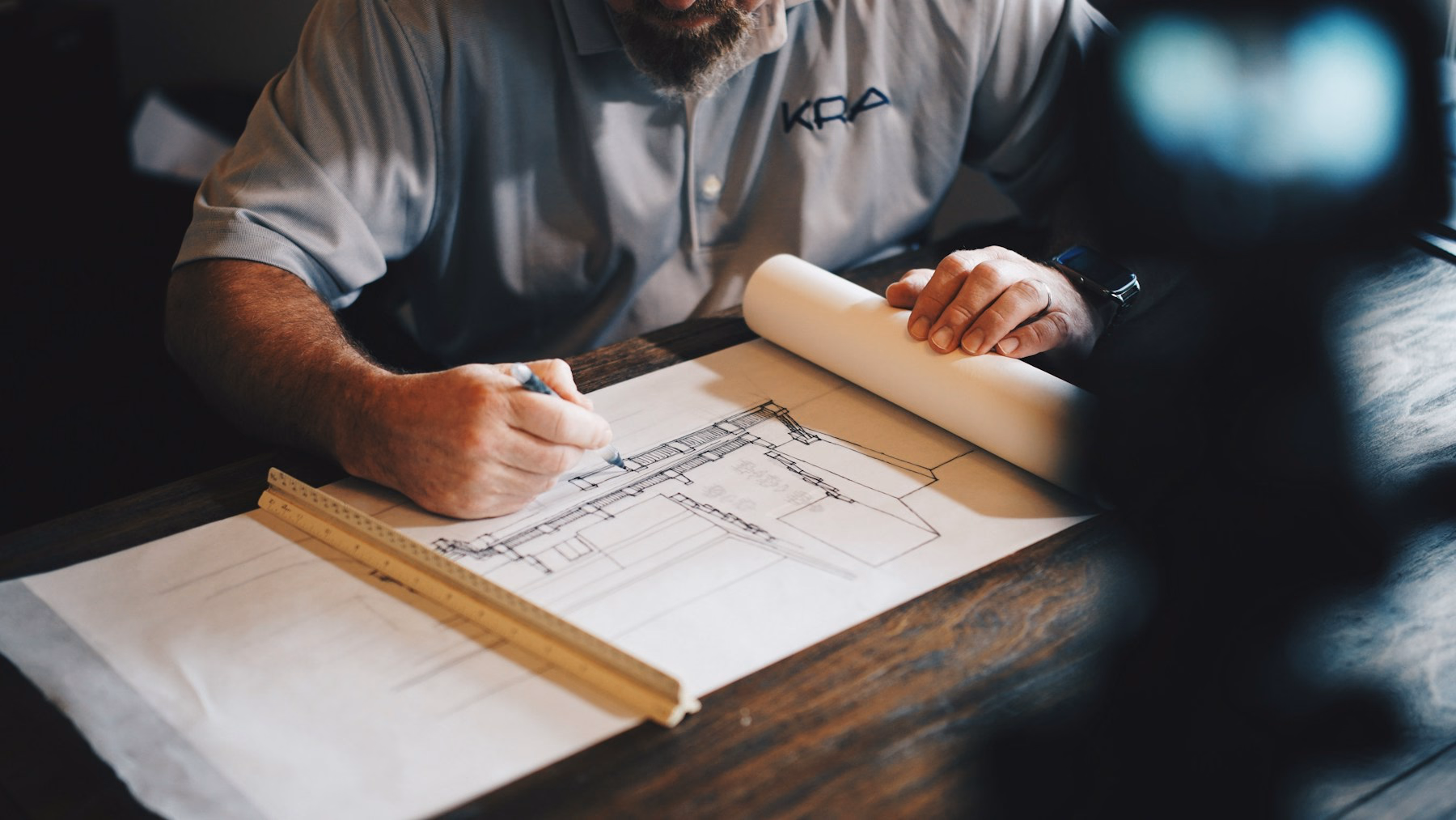 Profesional revisando planos arquitectónicos sobre una mesa